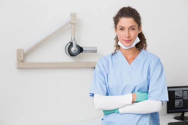 Стоматолог в синей форме улыбается в камеру — стоковое фото