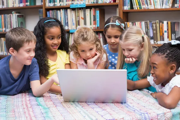 Eleverna tittar på bärbar dator i biblioteket — Stockfoto