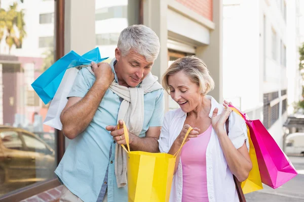 Gelukkige volwassen paar kijken naar hun winkelen aankopen — Stockfoto