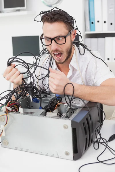 Ingénieur informatique en colère tirant des fils — Photo