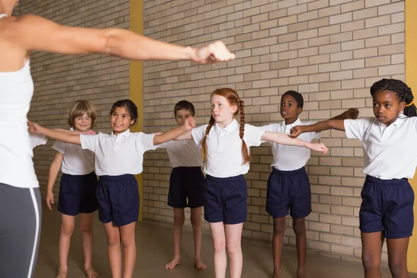 Cute pupils warming up in PE uniform — Φωτογραφία Αρχείου