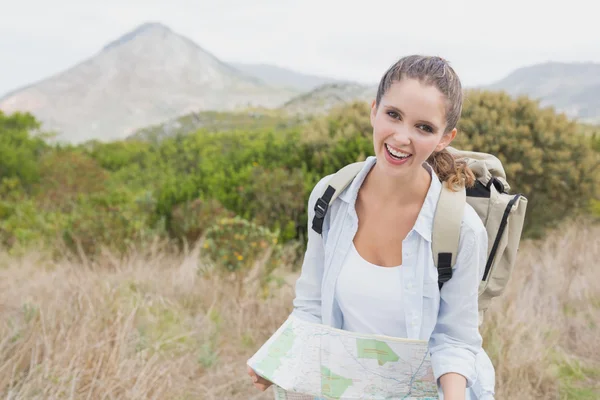 Retrato de una joven senderista sosteniendo mapa — Foto de Stock