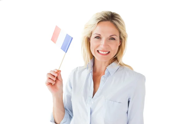 Femme blonde souriante tenant le drapeau français — Photo