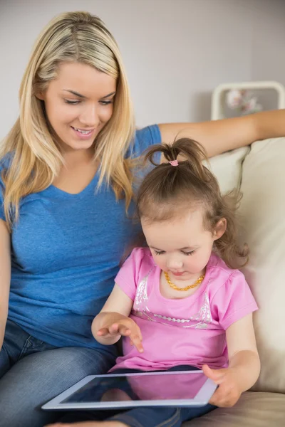 Mère et fille utilisant une tablette numérique sur le canapé — Photo