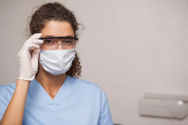 Dentiste en masque chirurgical et lunettes de protection — Photo