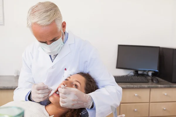 Стоматолог, осматривающий зубы пациента — стоковое фото