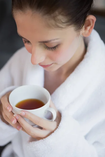 Hermosa mujer en albornoz tomando té — Foto de Stock