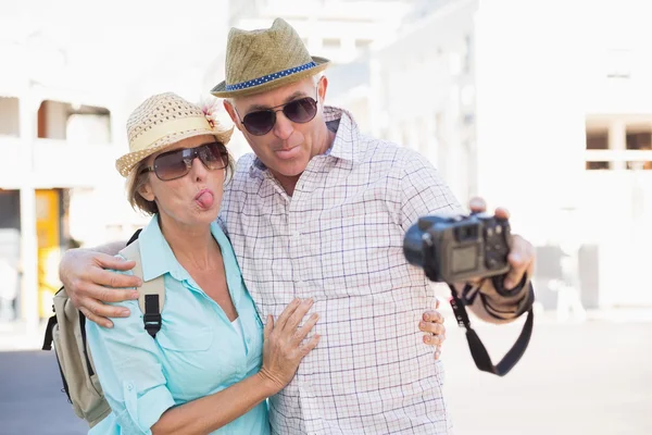 Happy tourist couple taking a selfie in the city — Stock Photo, Image