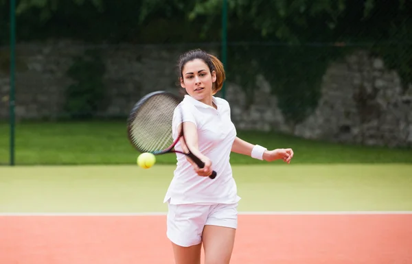 Jeune joueur de tennis frappant balle — Photo