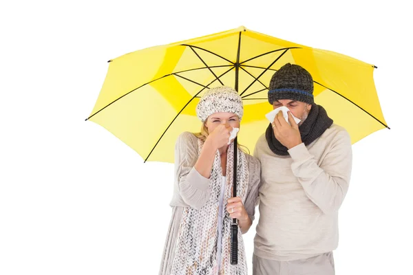 Couple in winter fashion sneezing under umbrella — Stock Photo, Image