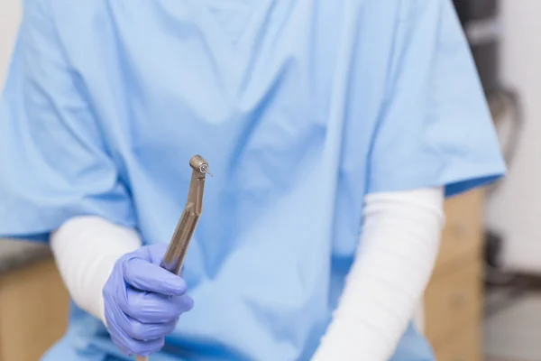 Dentista em esfoliação azul segurando broca dentária — Fotografia de Stock