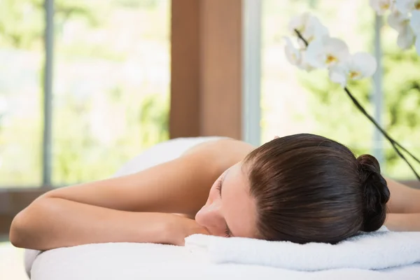 Hermosa mujer acostada en la mesa de masaje en el centro de spa — Foto de Stock