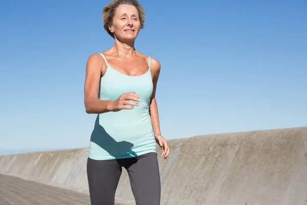 Femme âgée active jogging sur la jetée — Photo