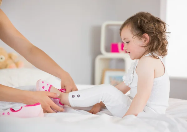 Mãe vestir-se filha na cama — Fotografia de Stock