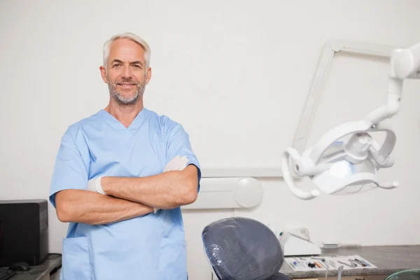 Dentista in camice blu sorridente alla macchina fotografica — Foto Stock