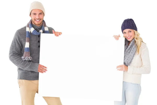 Atractiva pareja en invierno moda mostrando cartel — Foto de Stock