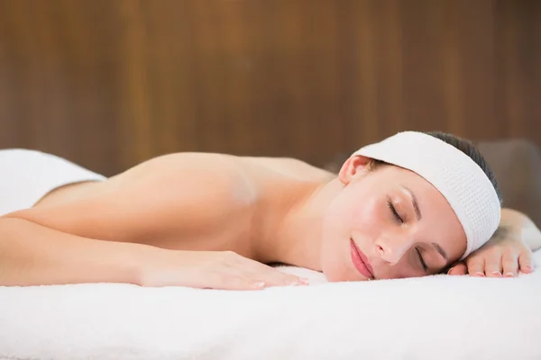 Vacker kvinna ligga på massagebänk på spacenter — Stockfoto