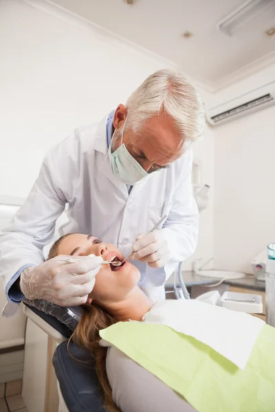 Dentista che esamina un paziente denti — Foto Stock