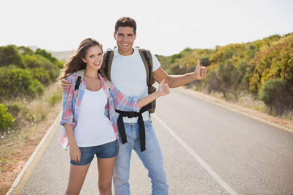 Couple hitchhiking on countryside road — Stock Photo, Image