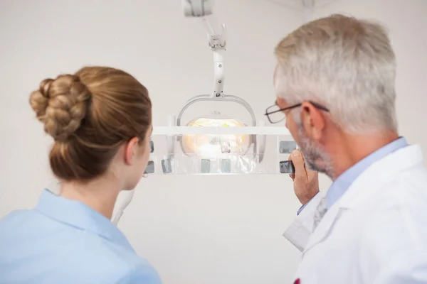 Dentista e assistente estudando raios-X — Fotografia de Stock