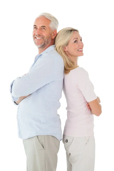 Sorrindo casal de pé encostado costas juntos — Fotografia de Stock