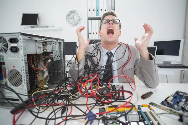 Engenheiro de computação estressado trabalhando em cabos quebrados — Fotografia de Stock