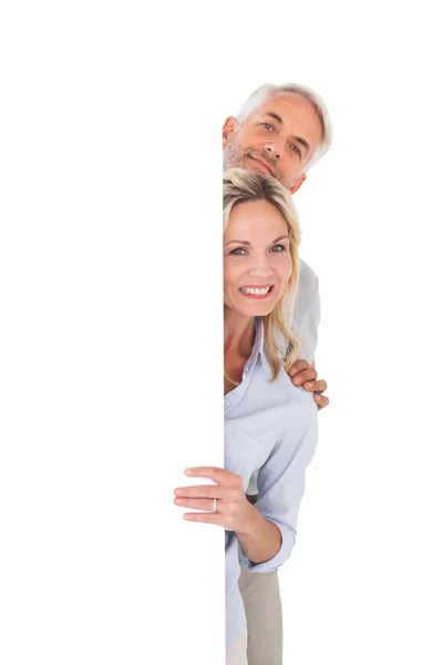 Happy couple showing large poster — Stock Photo, Image