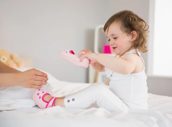 Moeder omhoog het kleden van jonge dochter op bed — Stockfoto