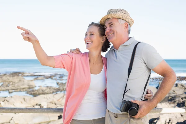 Pareja casual feliz mirando algo por la costa —  Fotos de Stock