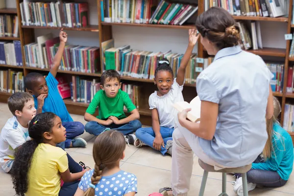 Pupils and teacher having class in library — Stock Photo, Image