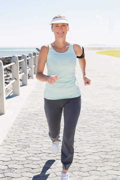 Fitte reife Frau joggt auf dem Pier — Stockfoto