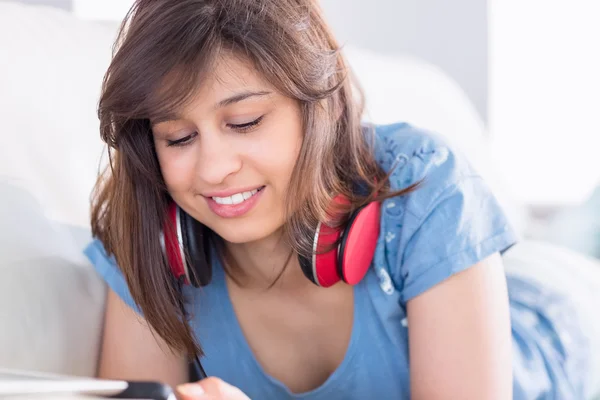 Hübsche Brünette mit Tablet-PC auf der Couch — Stockfoto