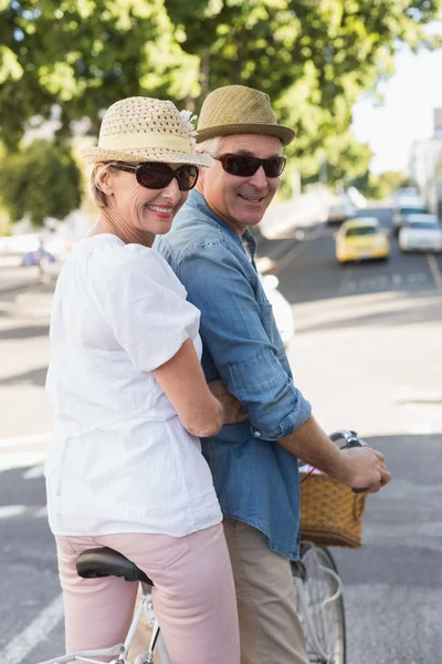 Feliz casal maduro indo para um passeio de bicicleta na cidade — Fotografia de Stock