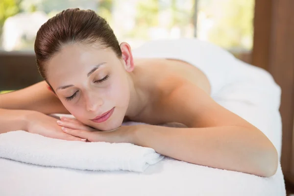 Hermosa mujer acostada en la mesa de masaje en el centro de spa — Foto de Stock