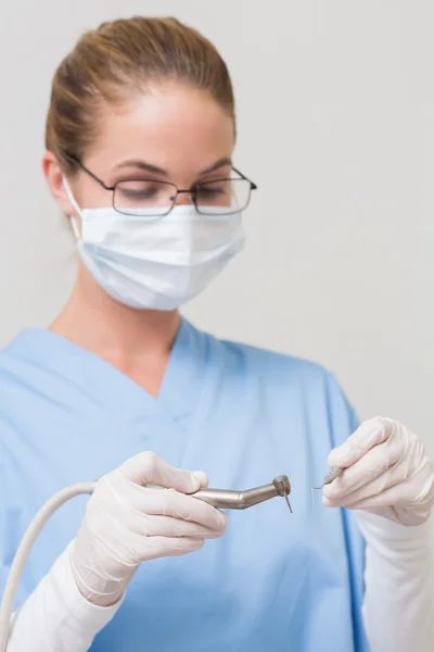 Dentista em azul esfrega segurando broca — Fotografia de Stock