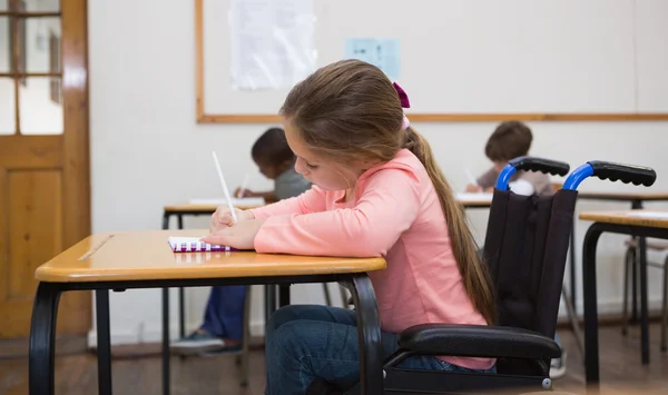 Aluno com deficiência escrevendo em sala de aula — Fotografia de Stock