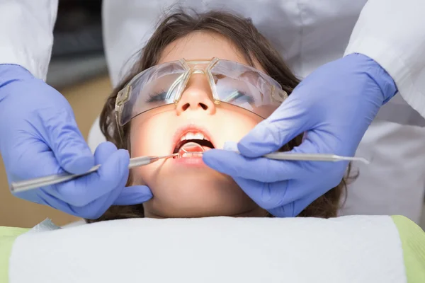 Odontólogo pediátrico examinando los dientes de un niño pequeño en los dentistas — Foto de Stock