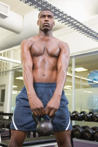 Gespierde man tillen waterkoker bell in gym — Stockfoto