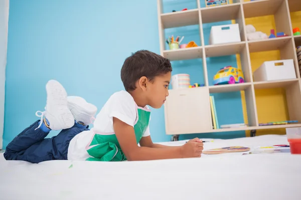 Little boy painting on floor in classroom — Stock Photo, Image