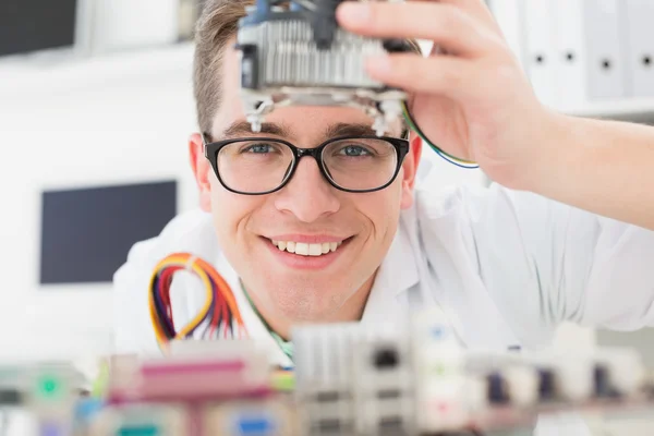 Técnico sonriente trabajando en la CPU rota —  Fotos de Stock