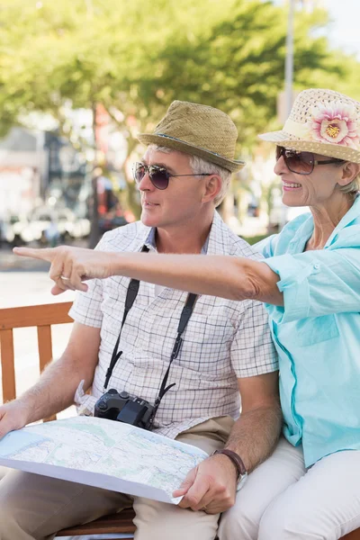 Happy tourist couple looking at map in the city — Stock Photo, Image