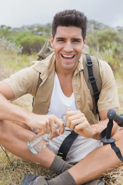 Cheerful hiking man sitting on mountain terrain — Stock Photo, Image