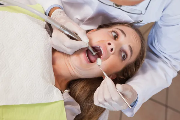 Zubař chystá vytáhnout vyděšený pacientům zubní — Stock fotografie