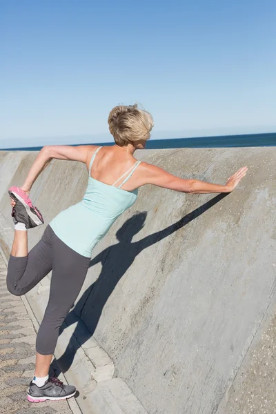 Actieve senior vrouw uitrekken op de pier — Stockfoto