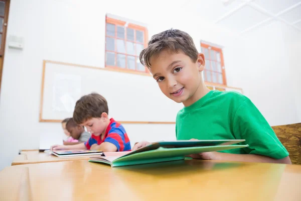 Lindos alumnos leyendo en escritorios — Foto de Stock