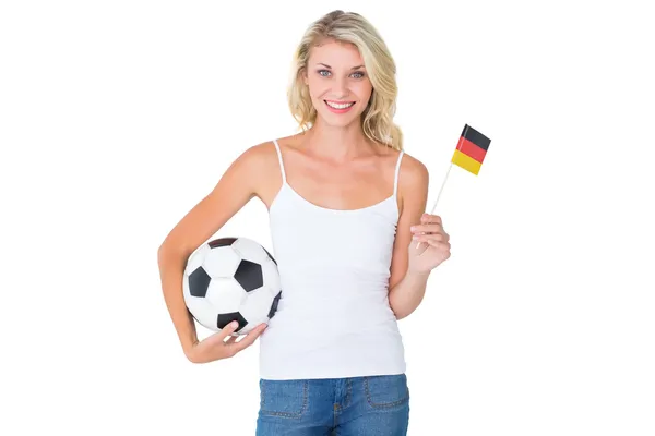 Jolie fan de football allemand agitant drapeau tenant le ballon — Photo