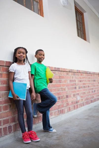 Cute pupils smiling in corridor — Stock Photo, Image