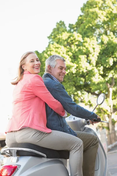 Happy senior couple riding a moped — Stock Photo, Image