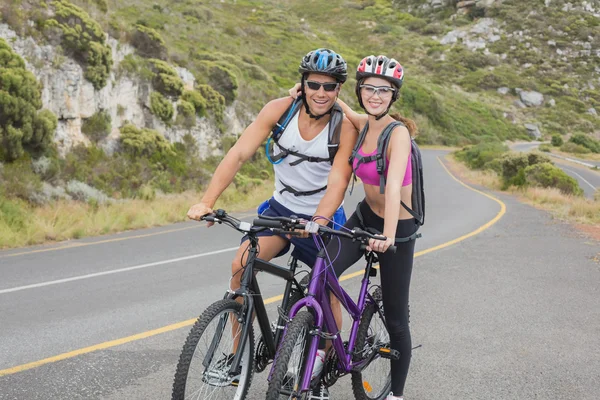 Athletic couple mountain biking — Stock Photo, Image