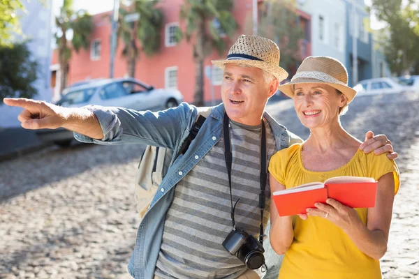 Gelukkig toeristische paar met behulp van gids boek in de stad — Stockfoto